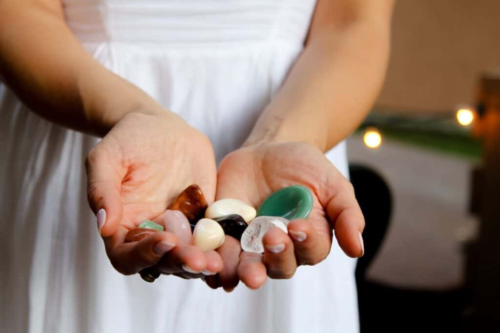 hands holding multicolored crystals