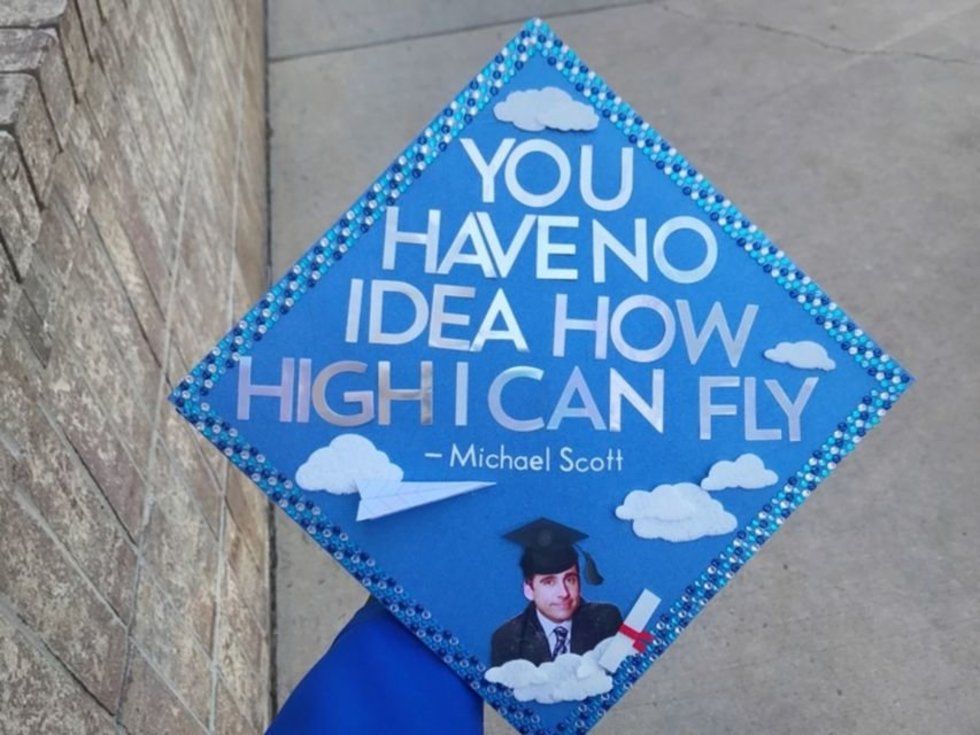 blue graduation cap with Michael Scott's face and the words you have no idea how high I can fly