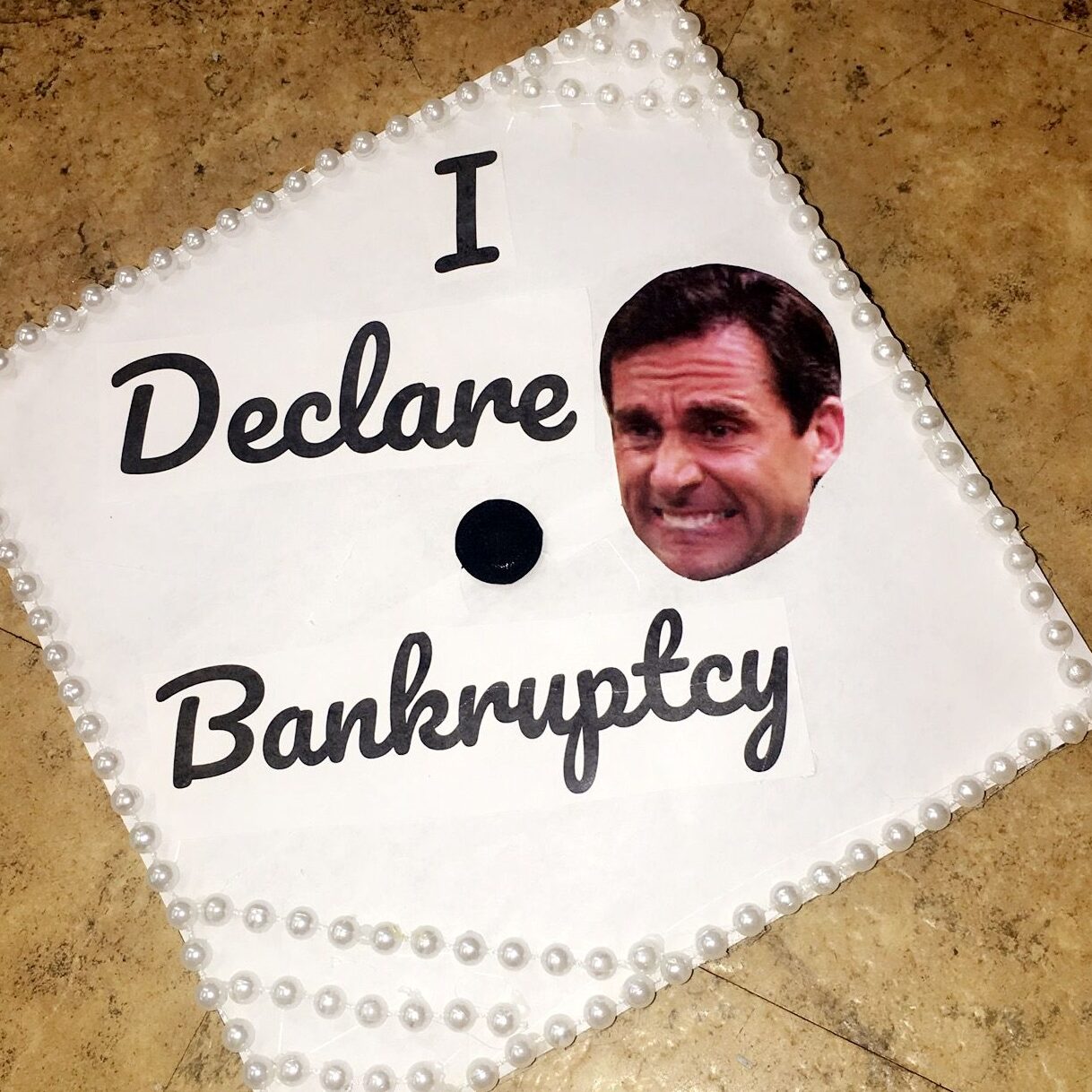 white graduation cap with Michael Scott and the words I declare bankruptcy