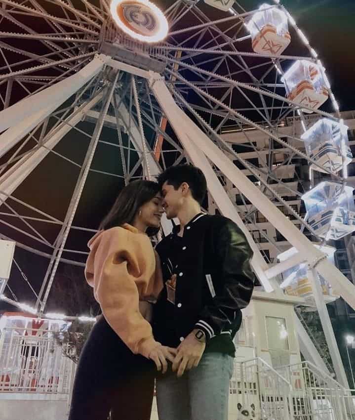 couple in front of ferris wheel