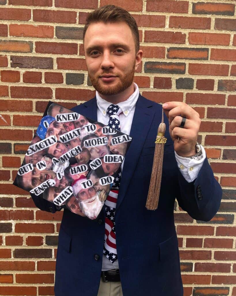 student holding graduation cap with pictures of Michael Scott's face on it