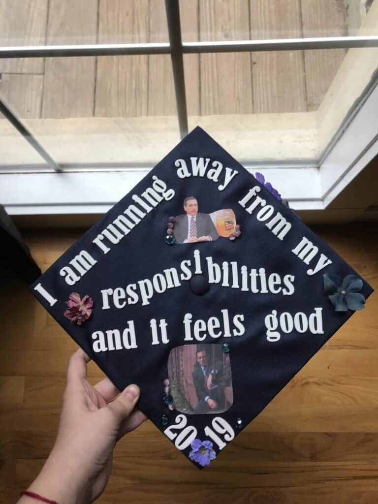 graduation cap with pictures of michael scott and the words I am running away from my responsibilities and it feels good