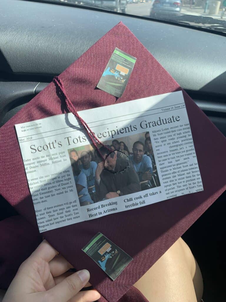 burgundy graduation cap with newspaper cutout