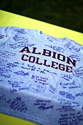 A gray Albion College t-shirt signed with numerous heartfelt messages and well-wishes.