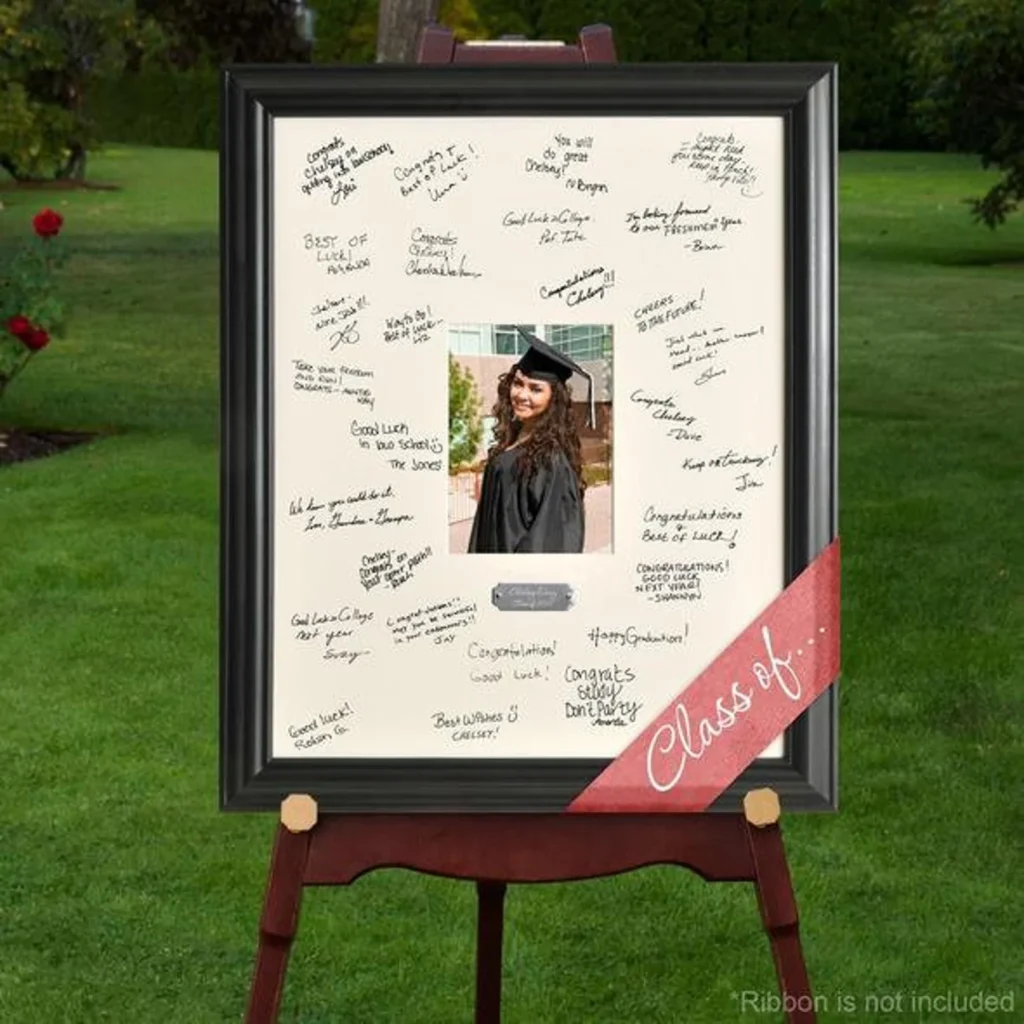 A framed mat surrounding a graduate's photo, filled with handwritten congratulatory messages from friends and family, displayed on an easel outdoors.