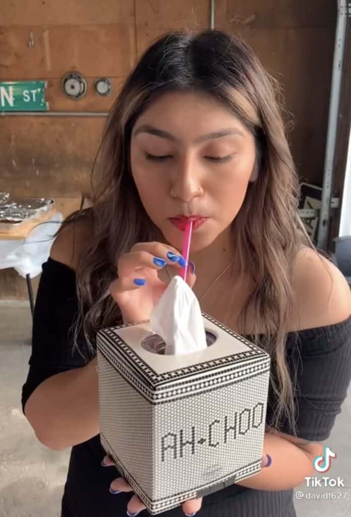 girl drinking from tissue box at anything but cups party