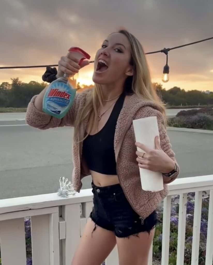 girl holding windex bottle up to open mouth