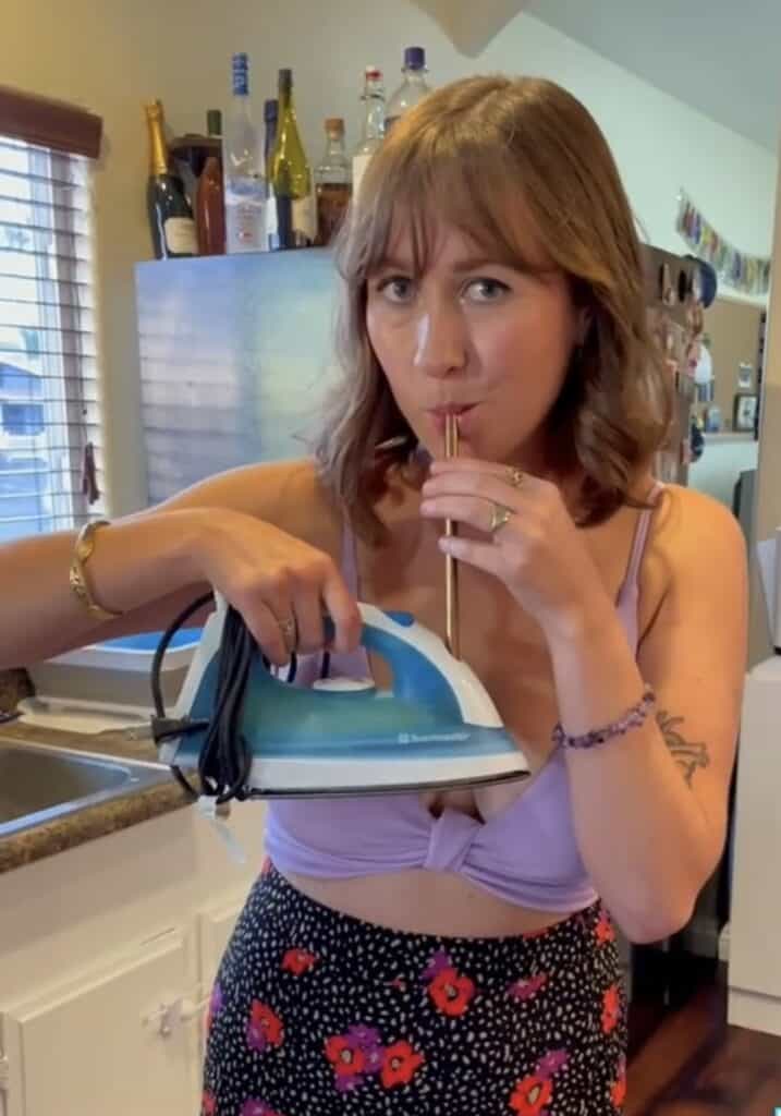 girl drinking out of iron with straw