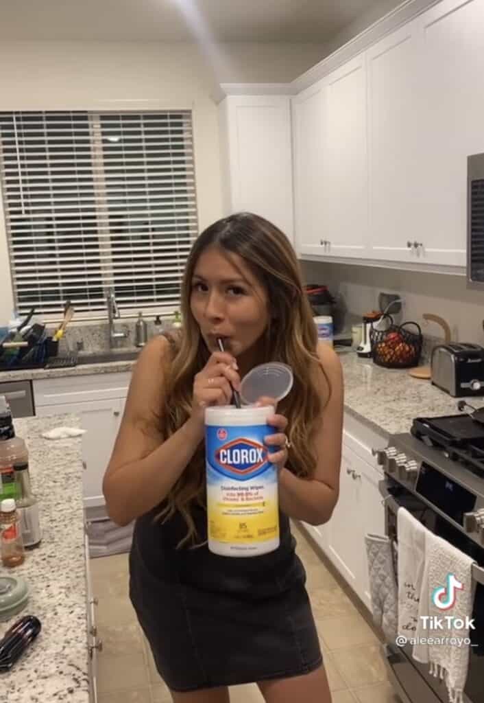 girl drinking from clorox wipes container with a straw