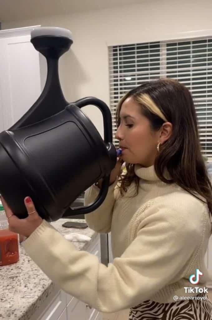 girl drinking from watering can