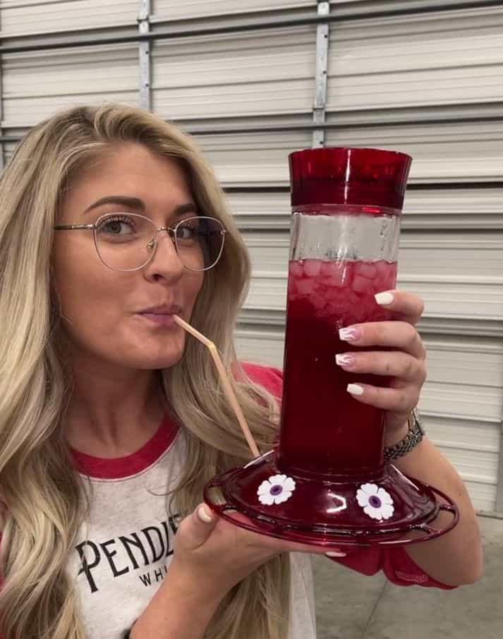 girl drinking from hummingbird feeder at anything but a cup party