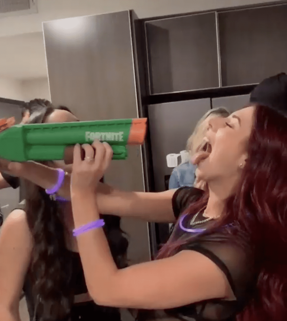 girl holding squirt gun near open mouth