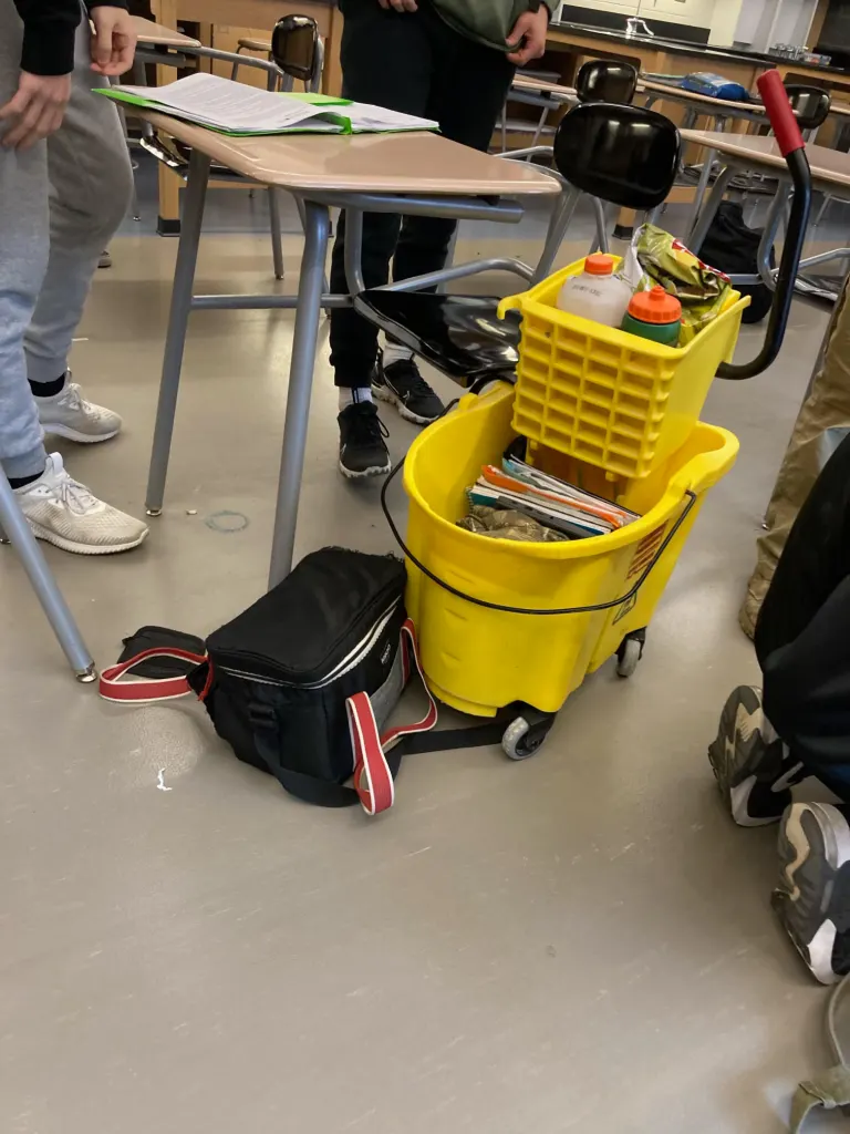 mop bucket with school supplies inside