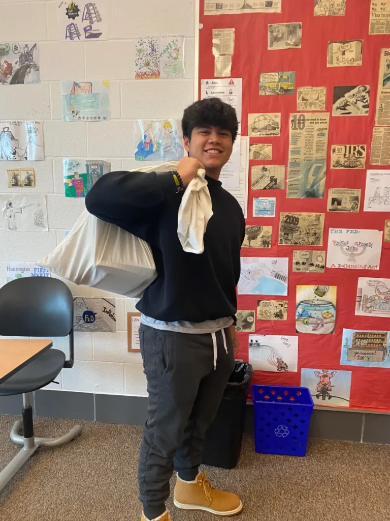 boy holding pillowcase for anything but a backpack day high school