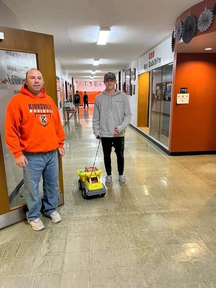 student walking down the hallway pulling a toy truck with a string
