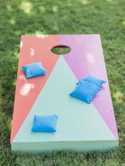 a colorful bag toss game on a grassy lawn