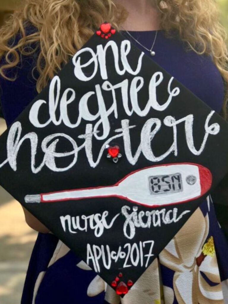 A creatively decorated black graduation cap with the phrase 'one degree hotter' in white cursive script, along with 'nurse Sierra APU '2017'.