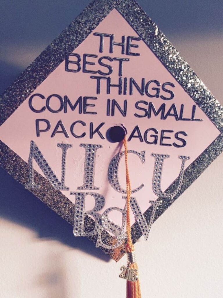 A diamond-shaped graduation cap with a light pink base, adorned with the sparkling message 'THE BEST THINGS COME IN SMALL PACKAGES NICU RN' in silver and gold glitter.