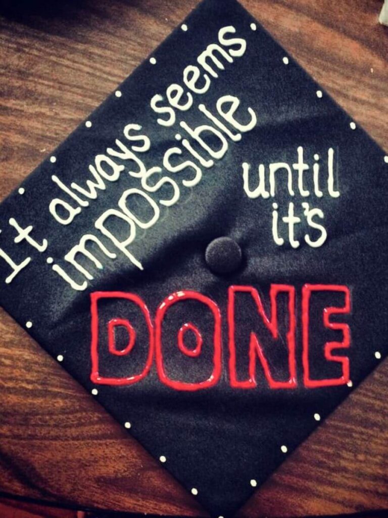 Inspirational graduation cap that reads "It always seems impossible until it's done" in white and red letters.